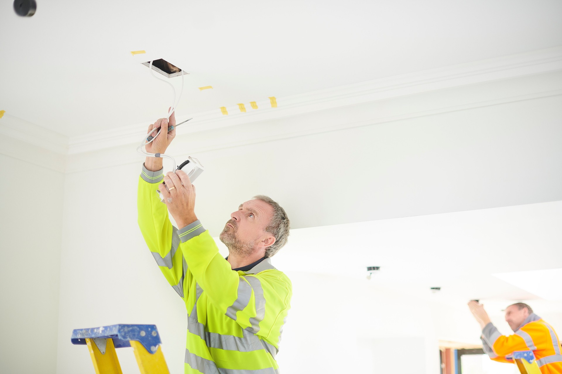 electrician installing downlights