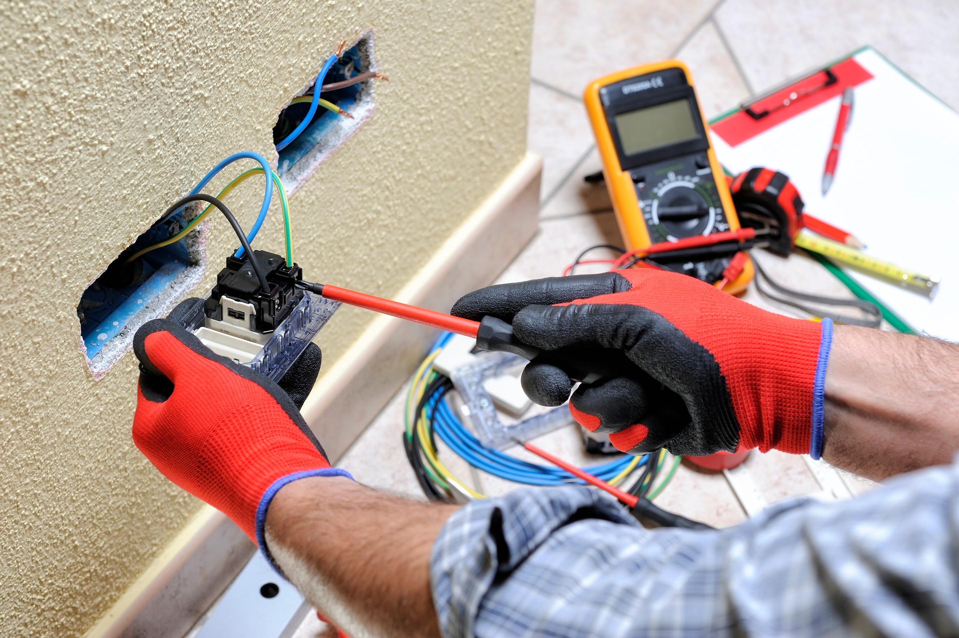 Electrician technician at work with safety equipment on a residential electrical system